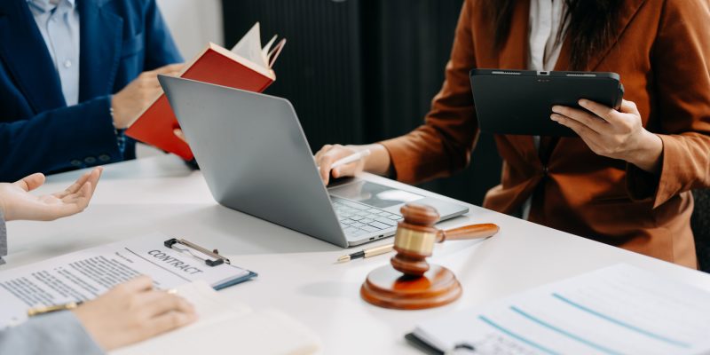 business people and lawyers discussing contract papers sitting at the table. Concepts of law, advice, legal services. in morning light