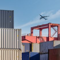 container-yard-closeup-with-airplane-in-sky-2023-11-27-04-50-06-utc.jpg